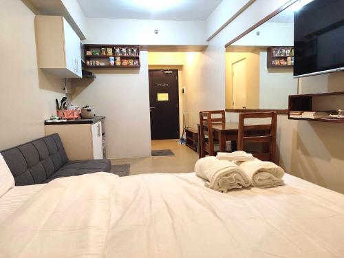 Habitación con cama, sala de estar y cocina. en TOWER 3 421 POOL VIEW, en Iloilo City