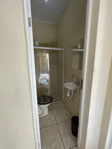 a small bathroom with a toilet and a sink at Casa Pelinca 1 quarto in Campos dos Goytacazes