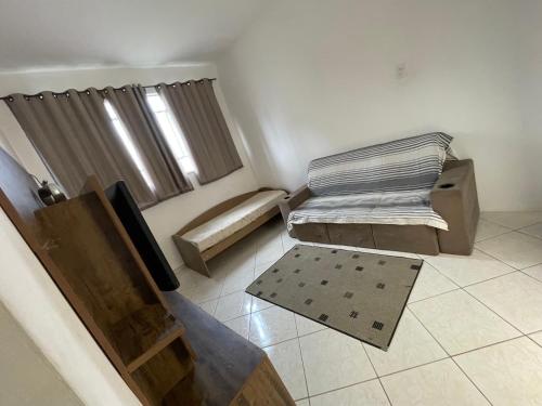 a small room with two beds and a window at Casa Pelinca 1 quarto in Campos dos Goytacazes