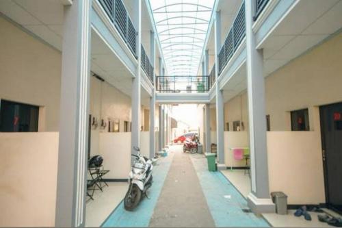 a hallway of a building with a motorcycle parked in it at Wisma Merdeka Syariah RedPartner in Palembang