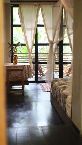 - une chambre avec un lit, une table et une fenêtre dans l'établissement Kapievi Ecovillage, à Puerto Maldonado