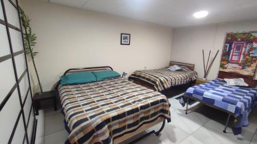 a room with two beds and a table in it at Acogedora e independiente casita - La Promotora in Cochabamba