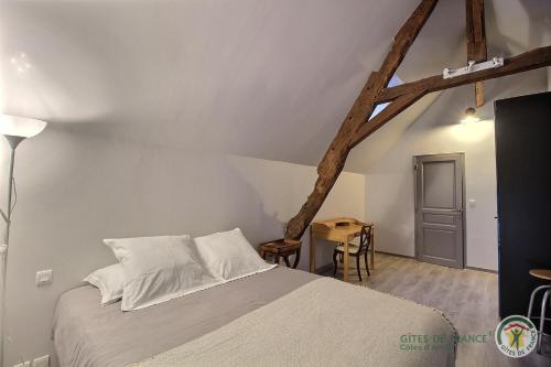 een slaapkamer met een wit bed en een tafel bij Duke du manoir in Paimpol