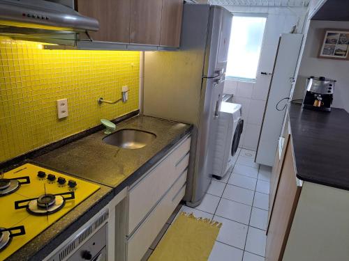 cocina pequeña con fregadero y fogones en Apartamento em Maceió com vista para o mar en Maceió