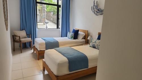 a hotel room with two beds and a window at Idyllic Beach Apartment in Bain Boeuf