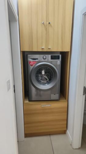 a washing machine in a wooden cabinet in a room at Idyllic Beach Apartment in Bain Boeuf