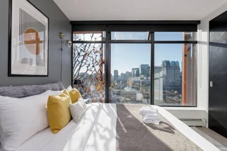 a bedroom with a bed with a view of a city at Cozy 1BR Condominium Suite in West Cordova in Vancouver
