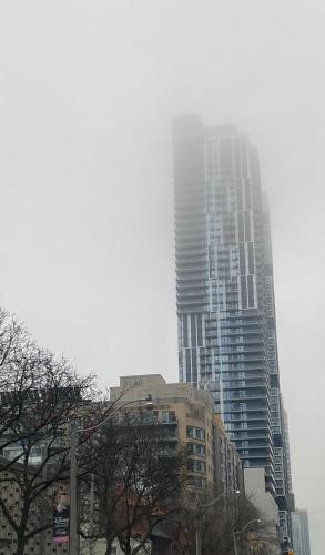 Un edificio alto in una città con alberi in primo piano di Cozy holiday home a Toronto