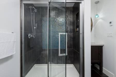 a shower with a glass door in a bathroom at The Spacious Haven at West 27th in Vancouver