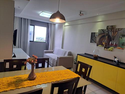 cocina y sala de estar con mesa y sillas en Apartamento em Maceió com vista para o mar en Maceió