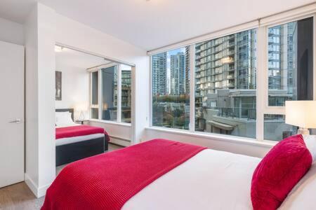 a bedroom with two beds and a large window at Heart of Downtown Luxury 2BR Condominium in Vancouver