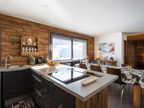 Il comprend une cuisine avec des murs en bois et une grande fenêtre. dans l'établissement Duplex de Luxe au Cœur de La Clusaz, 6 Pers, 118m², Proche Pistes et Loisirs - FR-1-304-286, à La Clusaz