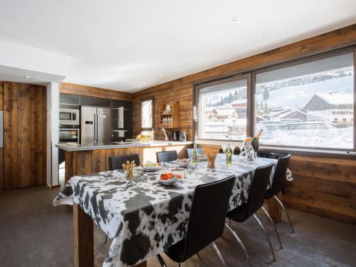 une salle à manger avec une table et une cuisine dans l'établissement Duplex de Luxe au Cœur de La Clusaz, 6 Pers, 118m², Proche Pistes et Loisirs - FR-1-304-286, à La Clusaz