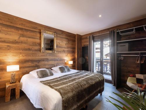 - une chambre avec un grand lit et des murs en bois dans l'établissement Duplex de Luxe au Cœur de La Clusaz, 6 Pers, 118m², Proche Pistes et Loisirs - FR-1-304-286, à La Clusaz