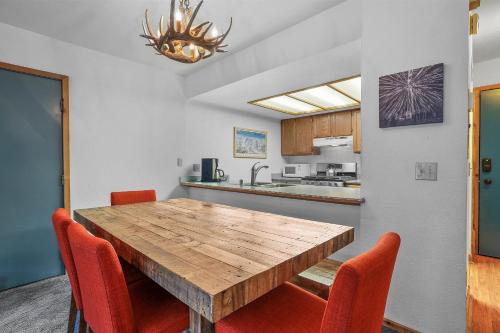 una cocina con mesa de madera y sillas naranjas en Cozy Kirkwood Condo – The Meadows 2 Bedroom condo, en Kirkwood
