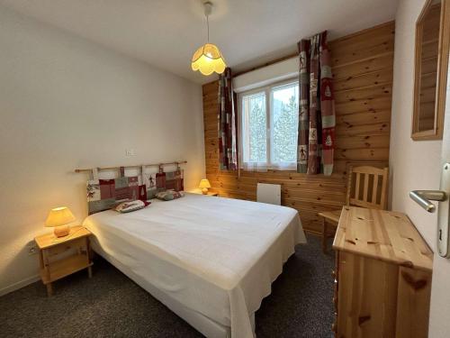 une chambre avec un grand lit et une fenêtre dans l'établissement Charmant T3 avec balcon, 4 couchages, à 500m des pistes - La Salle les Alpes - FR-1-330F-229, à La Salle Les Alpes