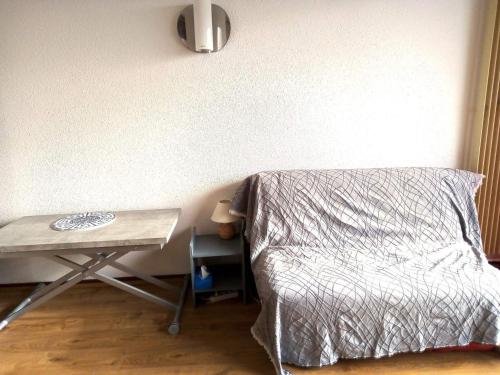 - une chambre avec un lit et une table à côté dans l'établissement Studio rénové 4 pers au pied des pistes avec équipements complets - FR-1-689-131, à Villard-de-Lans