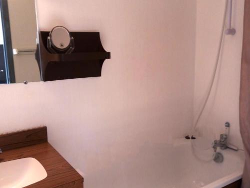 La salle de bains est pourvue d'un miroir, d'un lavabo et d'une baignoire. dans l'établissement Studio rénové 4 pers au pied des pistes avec équipements complets - FR-1-689-131, à Villard-de-Lans