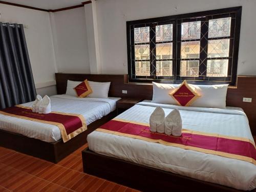 a bedroom with two beds with shoes on them at VangVieng Charming Boutique Hotel in Vang Vieng