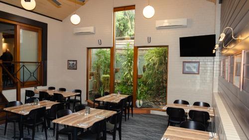 a restaurant with tables and chairs and a large window at Victoria Hotel Strathalbyn in Strathalbyn