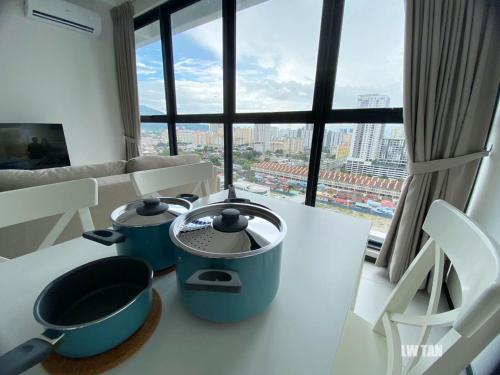 een keuken met twee potten op een tafel voor een raam bij Urban Suites Sea & City View Apartment in Jelutong