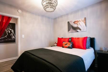 a bedroom with a bed with red pillows and a chandelier at Date Night - Ooo La La in Knoxville