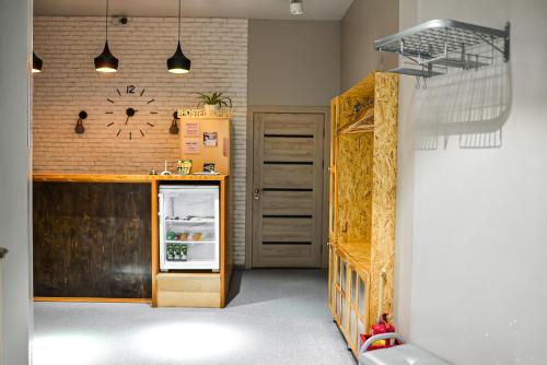 a kitchen with a refrigerator and a brick wall at Hostel Forum in Astana
