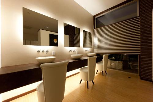 een badkamer met 2 wastafels en 2 spiegels bij インランド・シー・リゾート　フェスパ in Shimo-yuge