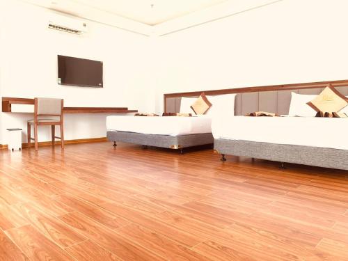 a room with two beds and a flat screen tv at Bờ Biển Vàng Resort in Ke Ga