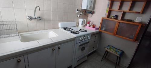 cocina pequeña con fregadero y fogones en Apartamento Alberdi en Salta en Salta