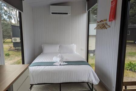 a bed with a stuffed animal sitting on top of it at Tiny House 18 at Grampians Edge in Dadswells Bridge