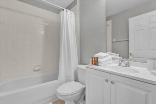 a white bathroom with a toilet and a sink at 3 Bedrooms - 2 Bathrooms - Cumbrian Lakes 4695 Cl in Orlando