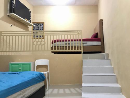 a room with two bunk beds and a staircase at Grand Hagawa Syariah near Alun Alun Lamongan RedPartner in Lamongan