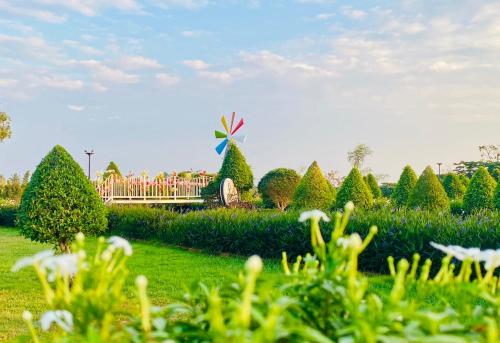 um grupo de pessoas em pé em uma ponte em um jardim em WHITE Houseรีสอร์ท em Ban Bung Thap Tae (1)