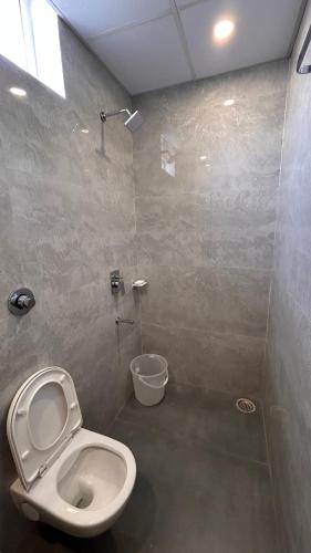 a bathroom with a toilet and a shower at Seasons Stay in Vijayawāda