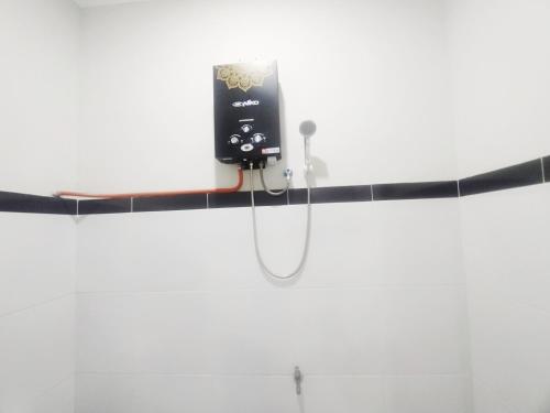 a cell phone hanging on a wall in a bathroom at RedDoorz Syariah Near Stasiun Purwokerto in Purwokerto