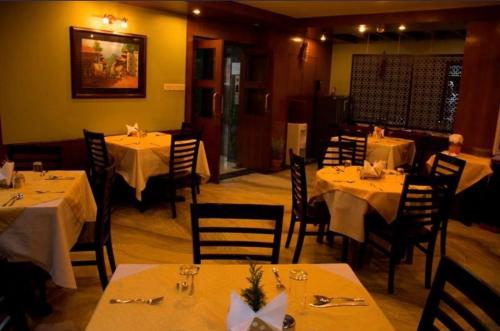 a restaurant with tables and chairs with white tablecloths at The Luxe Inn Boutique Hotel in Kathmandu
