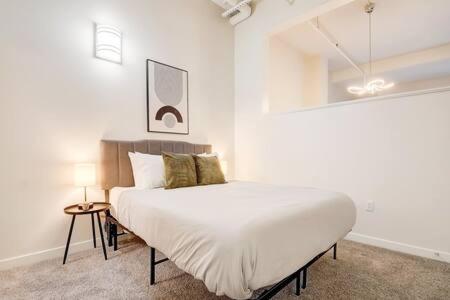 a white bedroom with a large bed in it at CozySuites - 1BR with Direct Skybridge Access #1 in Indianapolis