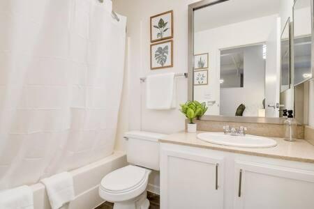 a white bathroom with a toilet and a sink at CozySuites - 1BR with Direct Skybridge Access #1 in Indianapolis