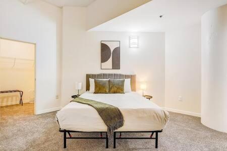 a bedroom with a large bed in a white room at CozySuites - 2BR with Direct Skybridge Access #1 in Indianapolis
