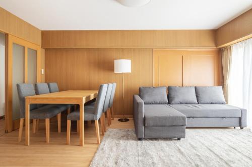 a living room with a couch and a table and chairs at A Marvelous Blend of Tradition and Modernity, Independent 1st-floor Suite, Accommodates Up to 10 Guests! in Tokyo