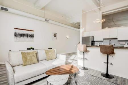 a living room with a white couch and a table at CozySuites - 2BR with Direct Skybridge Access #5 in Indianapolis