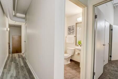 a white bathroom with a toilet and a sink at CozySuites - 2BR with Direct Skybridge Access #5 in Indianapolis