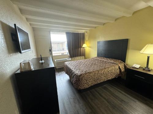 a hotel room with a bed and a window at James River Inn & Suites in Newport News