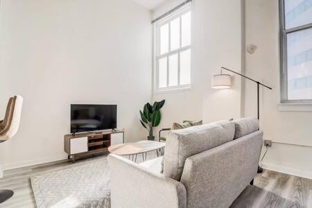 a living room with a couch and a tv at CozySuites - 2BR with Direct Skybridge Access #7 in Indianapolis
