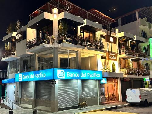 Hotel Agave Baños في بانوس: مبنى فيه كلب واقف امامه