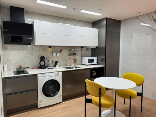 a kitchen with a washing machine and a table and chairs at Stay G7 Busan Station in Busan