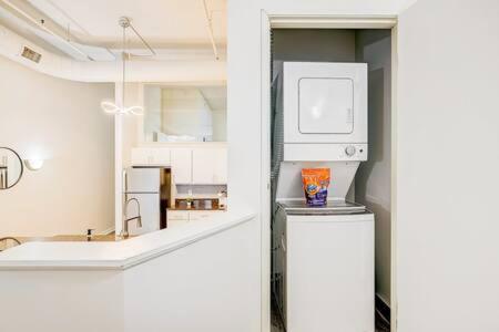 Il comprend une cuisine blanche équipée d'un réfrigérateur et d'un four micro-ondes. dans l'établissement TWO CozySuites Apartment with Skybridge Access #2, à Indianapolis