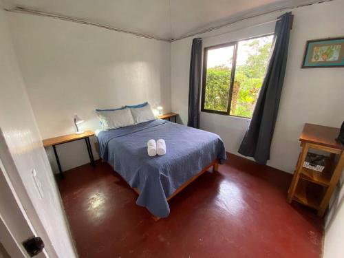 a bedroom with a bed with two shoes on it at Hijos del Bosque in Bijagua