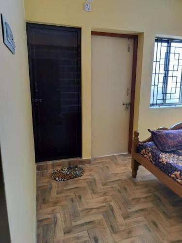 Pokój z drzwiami i drewnianą podłogą w obiekcie Pearl Guest House w mieście Ćennaj